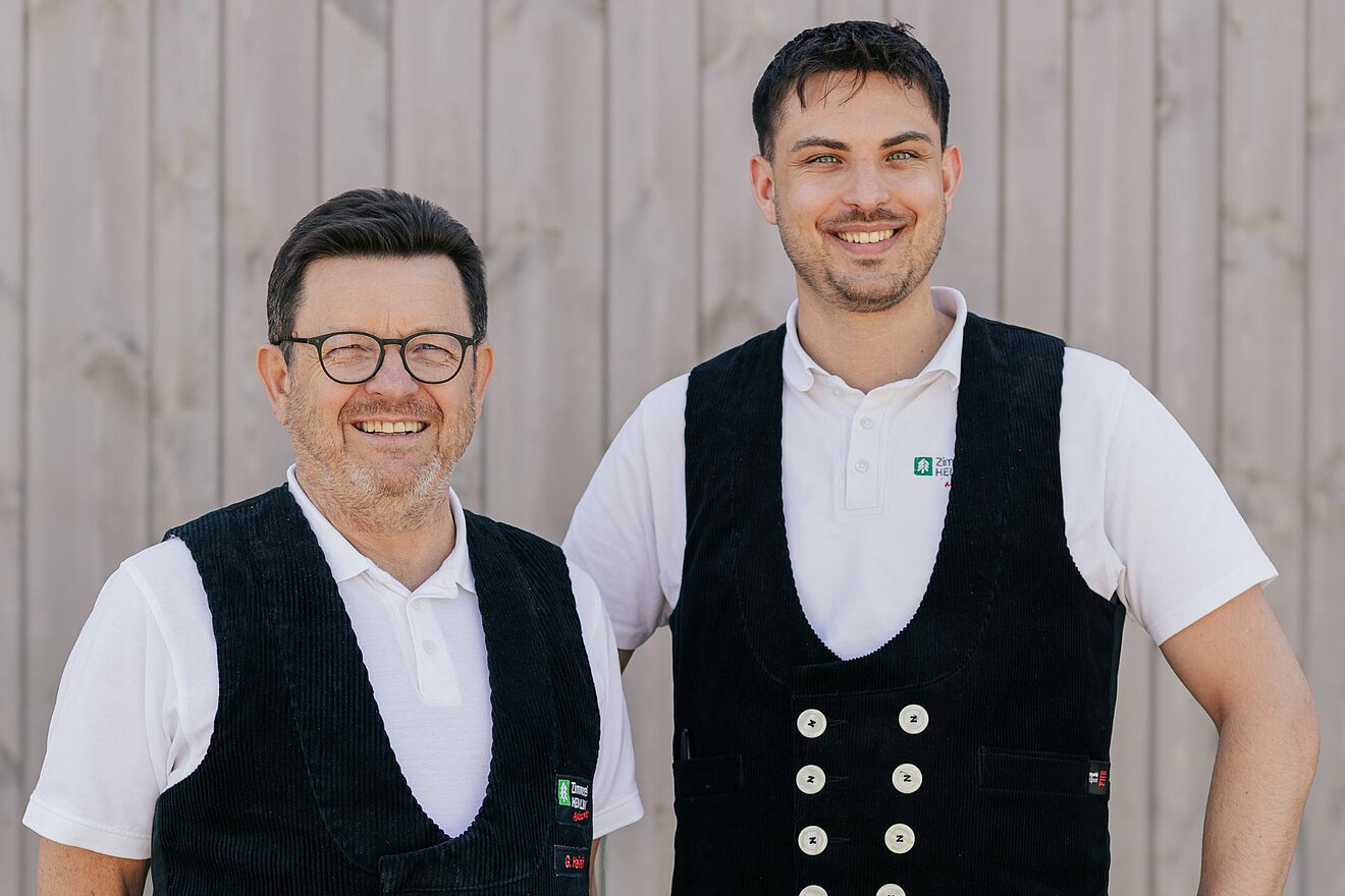Teamfoto Zimmerei Heinlein Heinlein Senior und Heinlein Junior mit traditioneller Zunftkleidung – Handwerksstolz bei der Zimmerei Heinlein